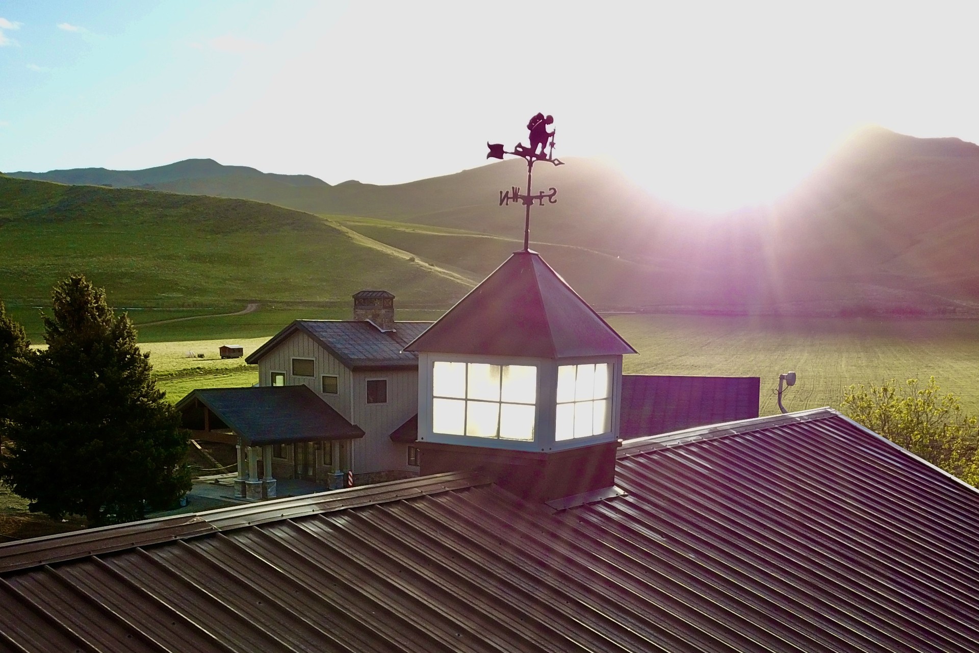 The main lodge at sunrise, cupola and weather vane catching the first light of the Morgan Valley